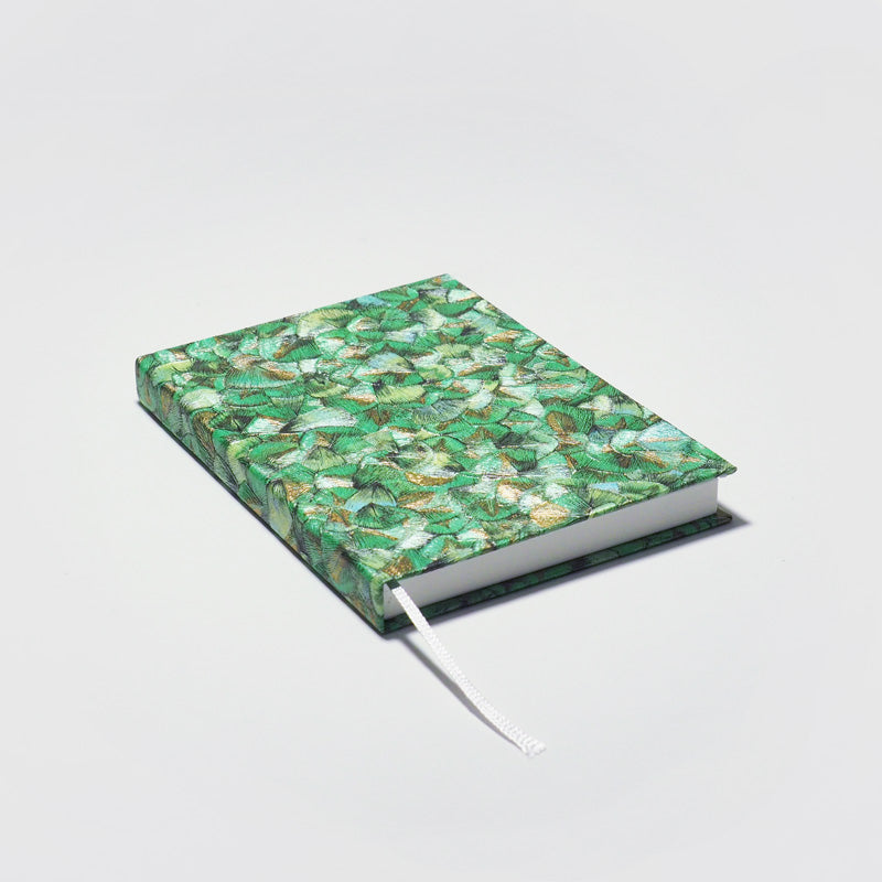 Detailaufnahme eines handgefertigten Notizbuchs aus dem Atelier 1818 , Format A6, design Glööckler Plume Green