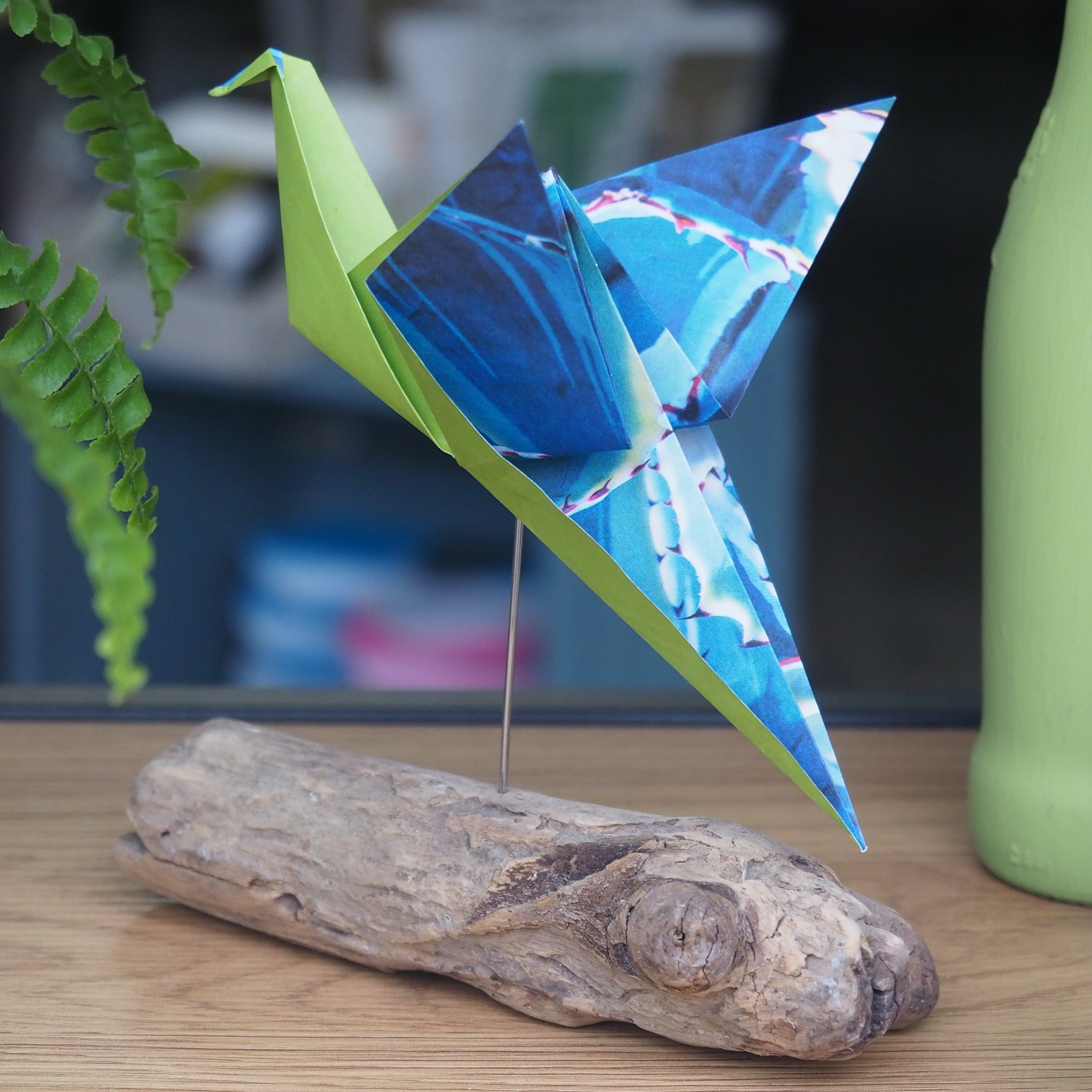 Origami Vogel auf einem Schwemmholz montiert
